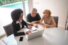 Real estate broker agent assisting couple with financial planning